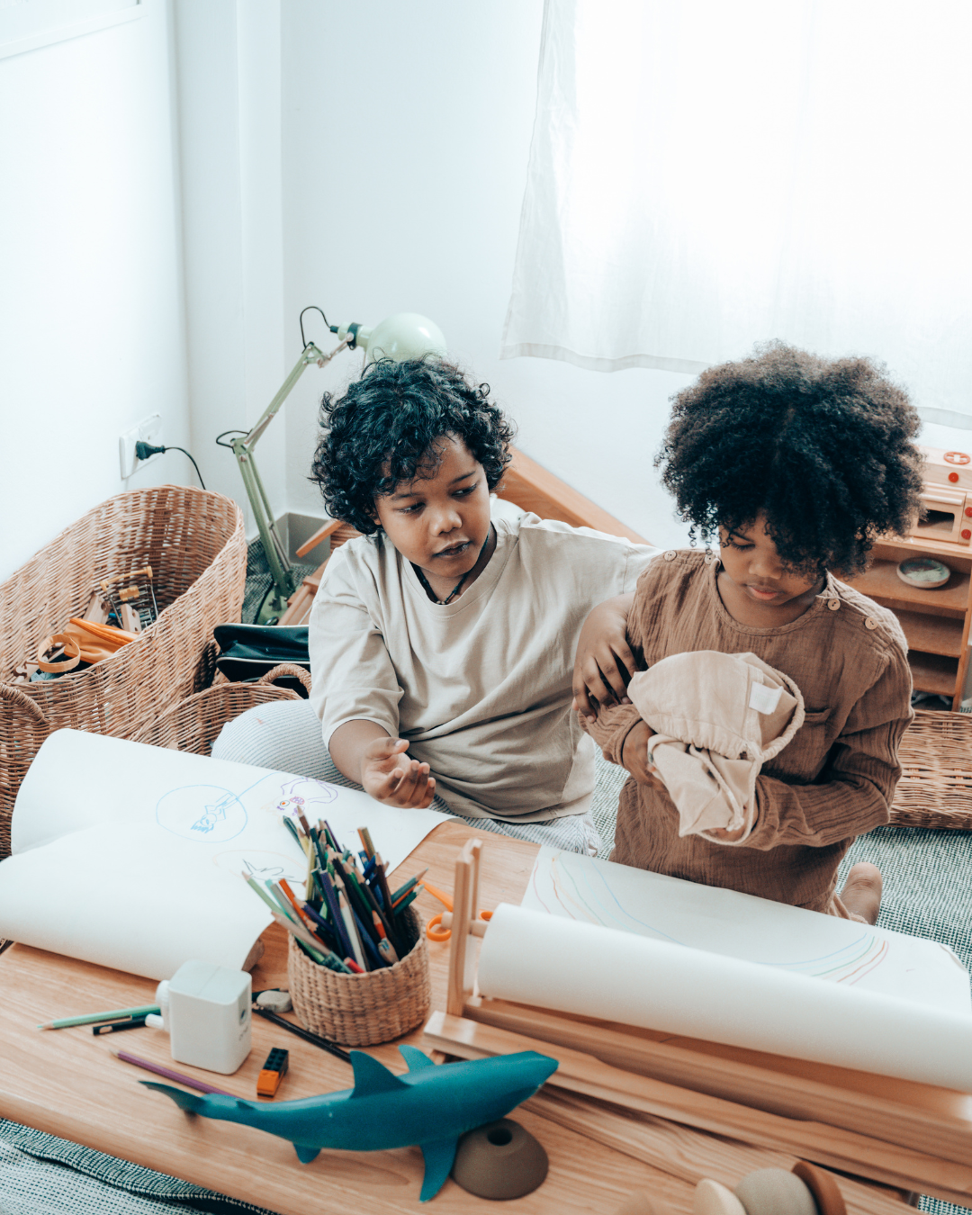 Two children playing and drawing together at home